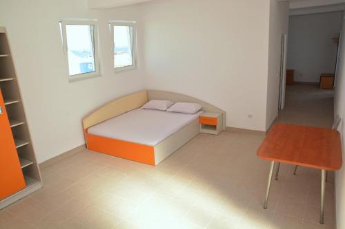 a small bedroom with a bed and a chair at Hostel Cazino Sud in Mamaia