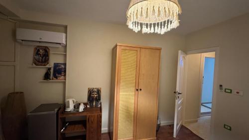 a room with a chandelier and a wooden door at RAFiF Pyramids View Hotel in Cairo