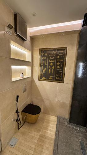 a bathroom with a black toilet in a room at RAFiF Pyramids View Hotel in Cairo