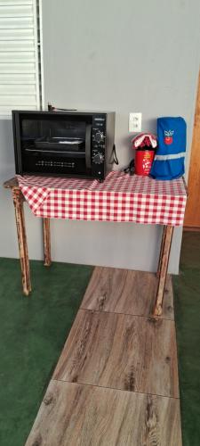 a table with a microwave on top of it at Recanto Morada do verde in Delfinópolis