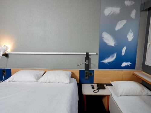 Una cama o camas en una habitación de ibis Auxerre Sud