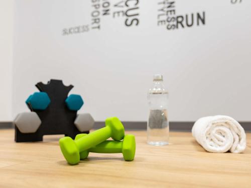 a table with green pipes and a bottle of water at Mercure Epinal Centre in Épinal