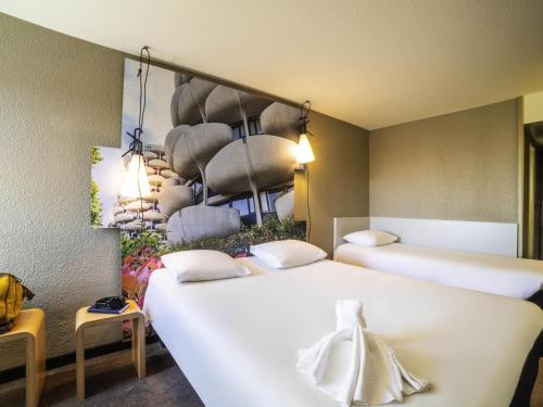 a hotel room with two beds and two tables at ibis Paris Creteil in Créteil