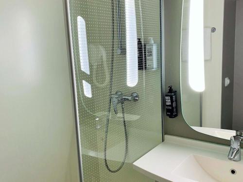 a shower in a bathroom with a glass wall at ibis Paris Creteil in Créteil