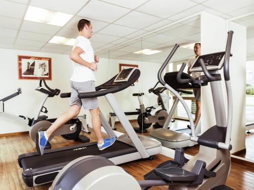 a man on a treadmill in a gym at Novotel Gent Centrum in Ghent