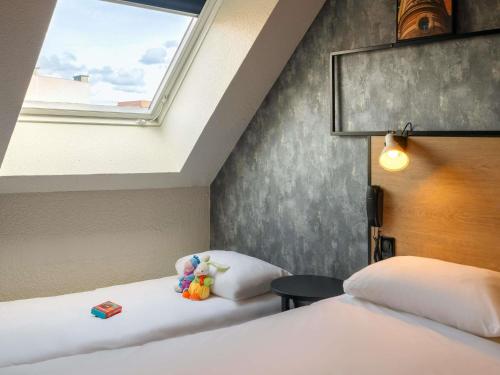 a bedroom with two beds and a window at ibis Epernay Centre Ville in Épernay
