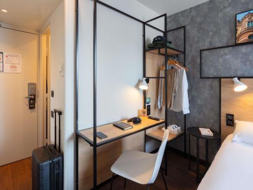 a hotel room with a desk and a bed and a room at ibis Epernay Centre Ville in Épernay