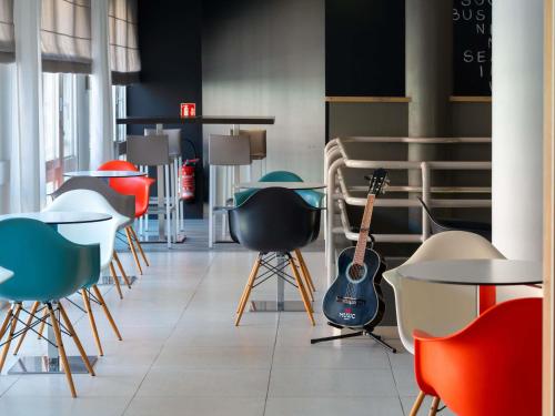 a room with a bunch of chairs and a guitar at ibis Epernay Centre Ville in Épernay
