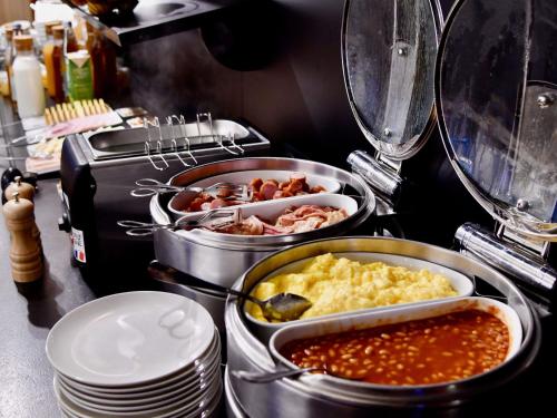a buffet with several trays of food on a counter at Ibis Nantes la Beaujoire Parc Expo in Nantes