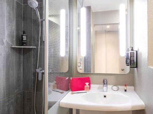 un bagno con lavandino e doccia di ibis Paris Gare du Nord La Fayette a Parigi