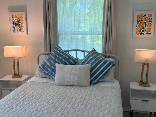 a bedroom with a bed with blue and white pillows at Osprey Coastal Retreat Near Siesta Key in Osprey