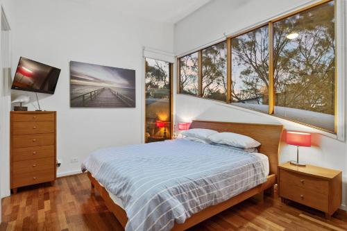 1 dormitorio con 1 cama y algunas ventanas en South Shores Villa 22, en Normanville