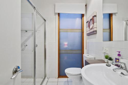 Un baño con ducha, inodoro y lavabo. en South Shores Villa 22, en Normanville