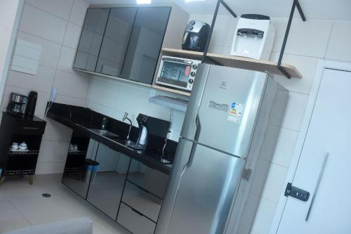 a kitchen with a refrigerator and a microwave at Apartamento Vista mar - Cais 410 in Recife