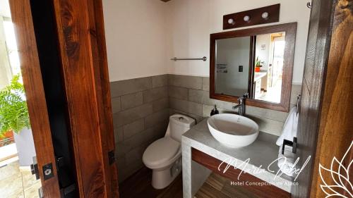 a bathroom with a sink and a toilet and a mirror at Hotel María Isabel Ataco in Concepción de Ataco