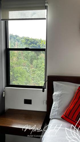 a bedroom with a window and a bed with a red pillow at Hotel María Isabel Ataco in Concepción de Ataco