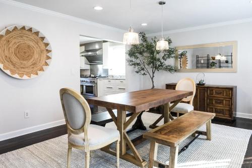 a kitchen and dining room with a wooden table and chairs at Cozy Home with POOL plus CHEFS kitchen in Prime Area in Charlotte