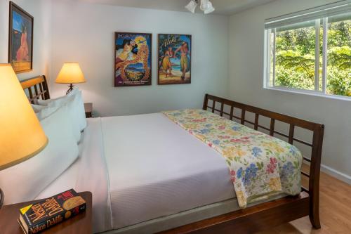 a bedroom with a white bed and two windows at 5th Street Ohana in Volcano