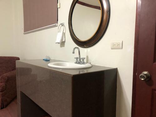 a bathroom with a sink and a mirror on the wall at Hotel oasis suites in Delicias