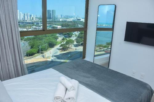 a hotel room with a bed with two towels at Vista mar - Flat Parque do Cais 1211 in Recife