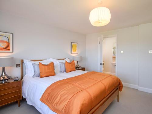 a bedroom with a large bed with an orange blanket at 3 Bed in Tenterden 83843 in Saint Michaels