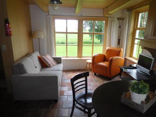 a living room with a couch and a chair at Logementen Jannum in Burdaard