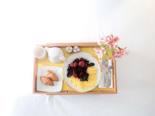 a tray with a plate of food with fruit and other foods at Novotel Athens in Athens