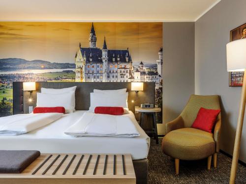 a hotel room with a large bed and a chair at Mercure München City Center in Munich