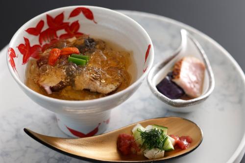 a bowl of soup on a plate with a spoon at Plaza Awajishima in Minamiawaji