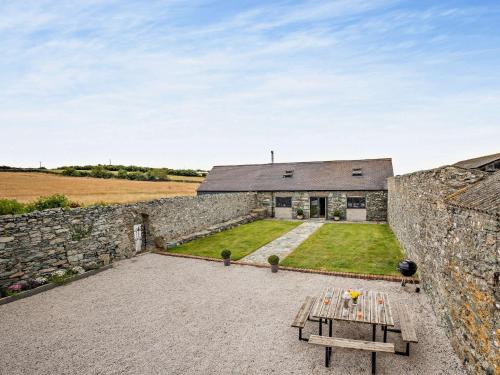 a house with a stone wall and a table at 4 Bed in Cemaes 90258 in Llanfechell