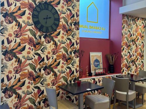 a restaurant with two tables and a clock on a wall at ibis Limoges Centre in Limoges
