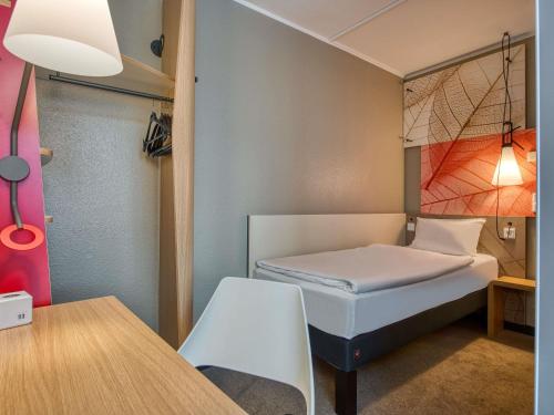 a small room with a bed and a table at ibis Nürnberg City am Plärrer in Nürnberg