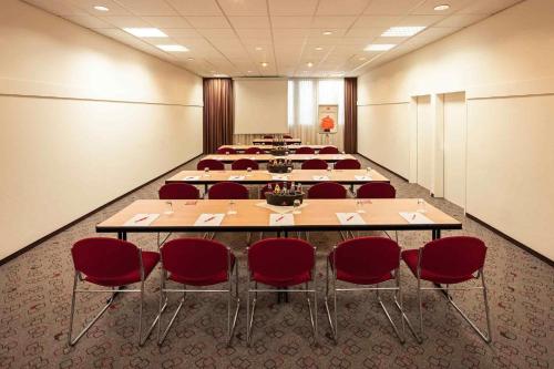 a large conference room with tables and red chairs at ibis Nürnberg City am Plärrer in Nürnberg