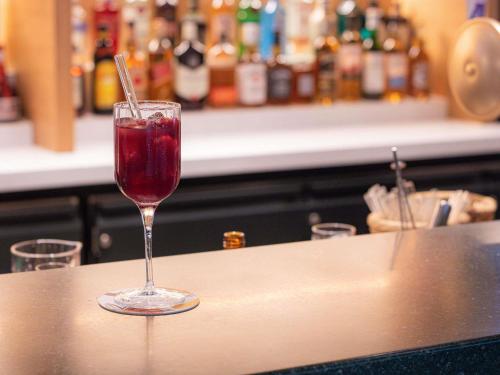 a wine glass sitting on top of a counter at Novotel Zürich Airport Messe - newly renovated in Glattbrugg
