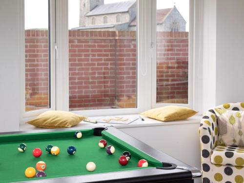 a pool table in a living room with windows at 4 Bed in West Runton 81469 in West Runton
