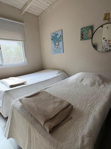 a bedroom with two beds and a mirror and a window at Casa de Flia in Villa Gesell
