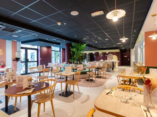 a restaurant with wooden tables and chairs in a room at ibis Lille Centre Gares in Lille