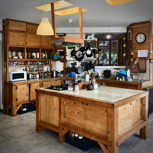 a large kitchen with wooden cabinets and a counter top at Quarto Limao Casa citrina in Lajes das Flores