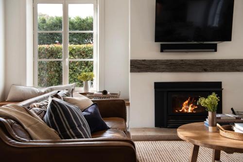 a living room with a couch and a fireplace at The French House- European inspired luxury in Trentham