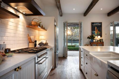 a kitchen with a stove top oven next to a sink at The French House- European inspired luxury in Trentham