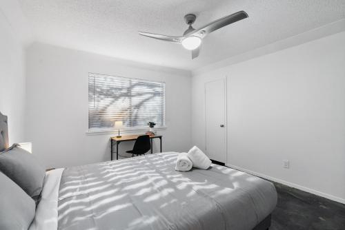 a white bedroom with a ceiling fan and a bed at Industrial Oasis Perfect Location Free Pkg in Austin