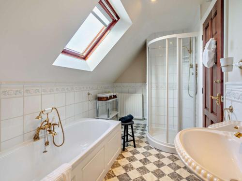 a bathroom with a tub and a shower and a sink at 4 Bed in Crosby-on-Eden 94398 in Crosby