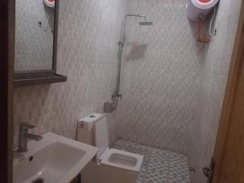 a small bathroom with a sink and a toilet at SPLENDID APARTMENTs in Mbarra Kunku