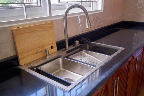 a kitchen sink with a faucet on top of it at Elegant Dar Suburb Hideaway2 in Dar es Salaam
