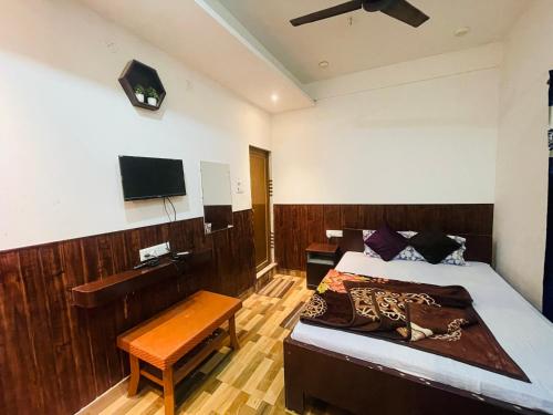 a bedroom with a bed and a flat screen tv at HOTEL ROYAL CiTY KOCH BEHAR in Koch Bihār