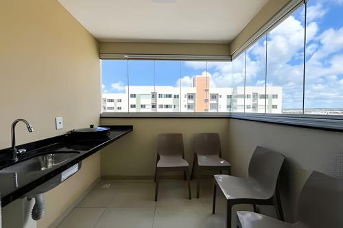 a bathroom with two chairs and a sink and a large window at Apto 2/4 com AR a 7min da Praia de Aruana in Santa Maria