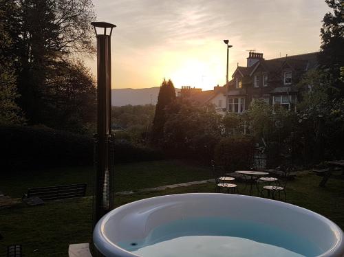 a bath tub in a yard with the sun setting at 9 Bed in Keswick SZ238 in Keswick
