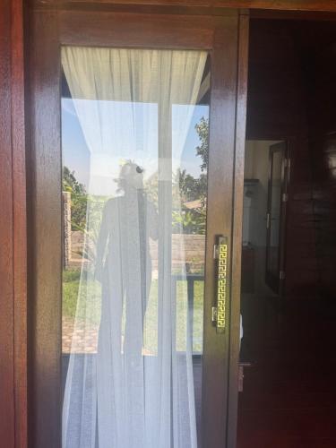 a silhouette of a man standing behind a window at Koceng Bungalows in Tetebatu