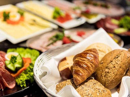 a plate of food with bread and pastries on a table at ibis Hotel Regensburg City in Regensburg