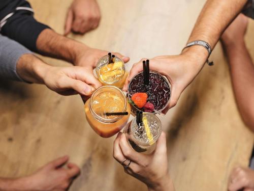 a group of people holding up three cocktails at ibis Hotel Regensburg City in Regensburg